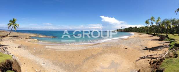 Coastline with sandy beach, palm trees and clear blue ocean at Bahía Villareal Palenque Colón Panama