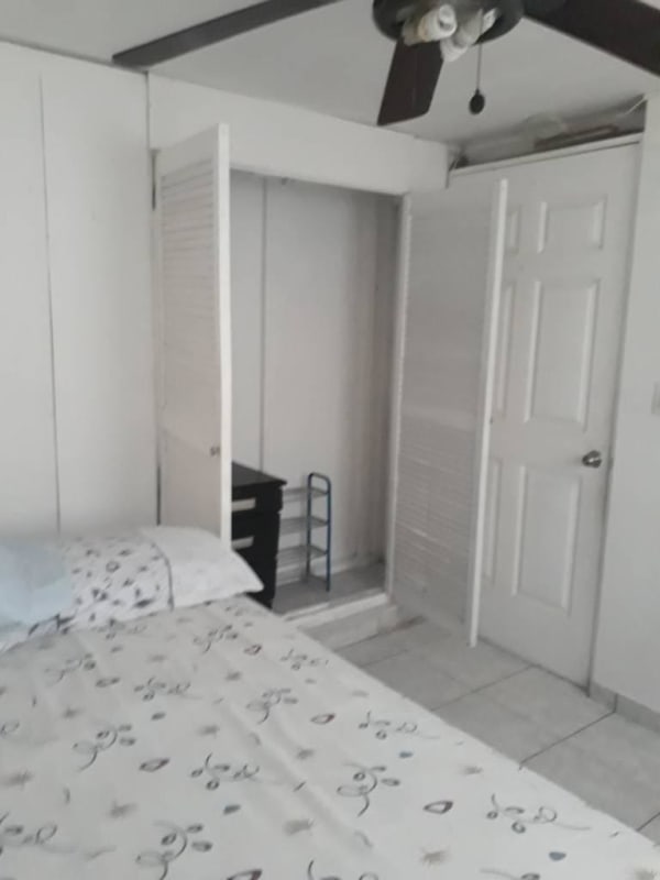 Bedroom with tiled floor, built-in closet, ceiling fan and simple furniture for rent in 12 de Octubre Panama City