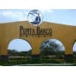 Mediterranean-inspired secure entrance arch of Punta Barco Resort with landscaping