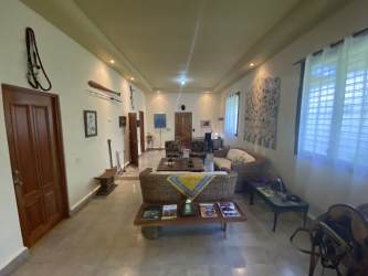 Spacious living room with wicker sofa, decorative art, tile flooring in San Carlos Panama