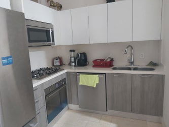 Modern white kitchen with stainless appliances, dual sink, microwave in Puntaarena Buenaventura Panama