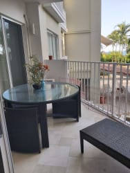 Balcony with glass table, black wicker lounge chairs, overlooking lush gardens in Puntarena Buenaventura Panama