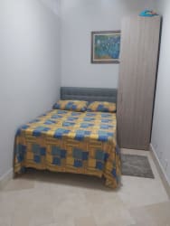 Open-plan living and dining with red sofa, white table and modern art in luxury rental Puntarena Buenaventura