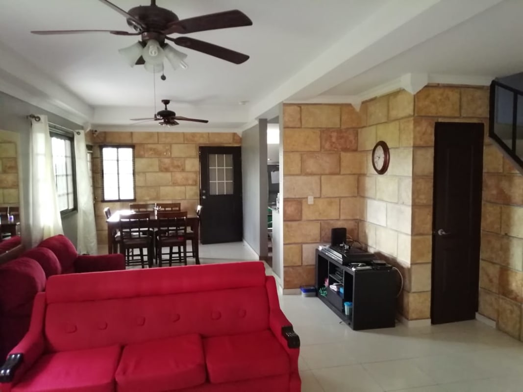 Contemporary bathroom with orange accent toilet, glass shower door and stylish finishes in house for sale Panama