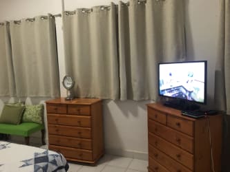 Coastal bedroom with patterned quilt arched window Isla Grande home Panama