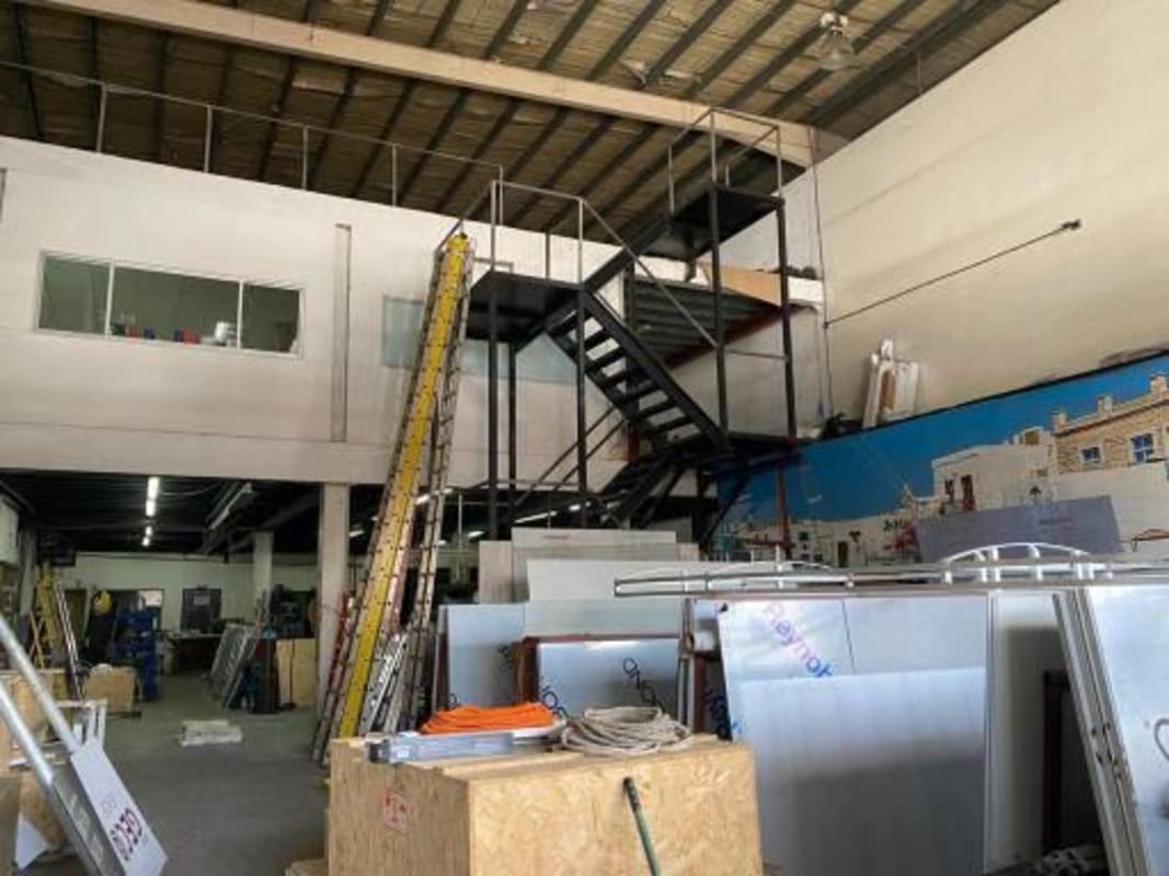 Bright cafeteria with tables, chairs, and kitchen area inside Costa del Este warehouse Panama