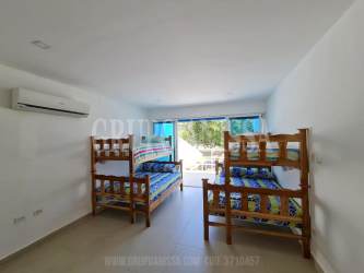 Minimalist white and green tiled bathroom with shower in beach townhouse Panama