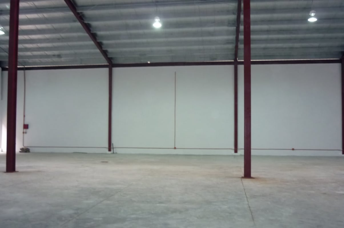 Open spacious warehouse with tall white walls and metal ceiling Panama