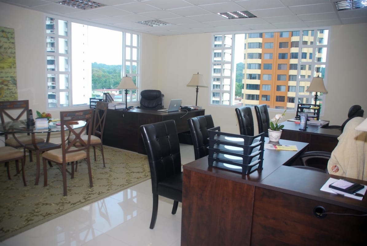 Bright shared modern office with wood desks, large windows and cityscape view at Camino de Cruces Business Center