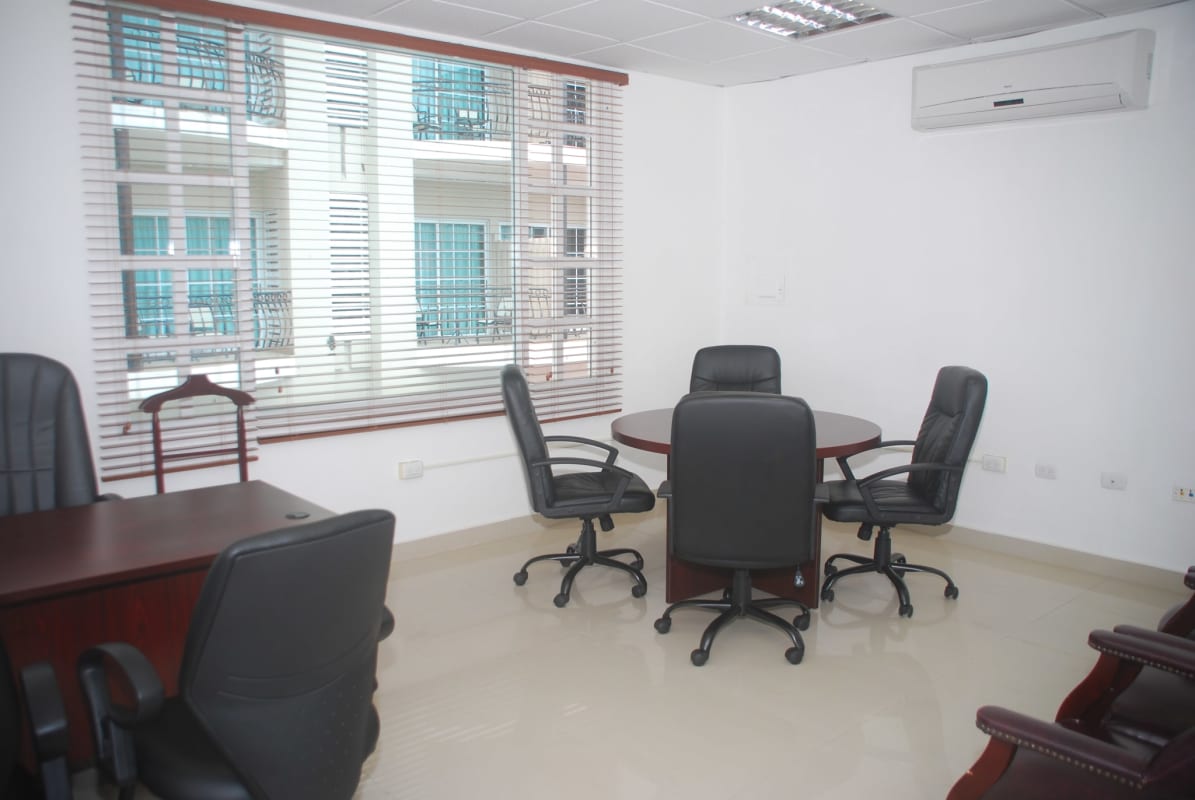 Contemporary office meeting room with round table, black chairs, large window and AC at Camino de Cruces Business Center Panama City