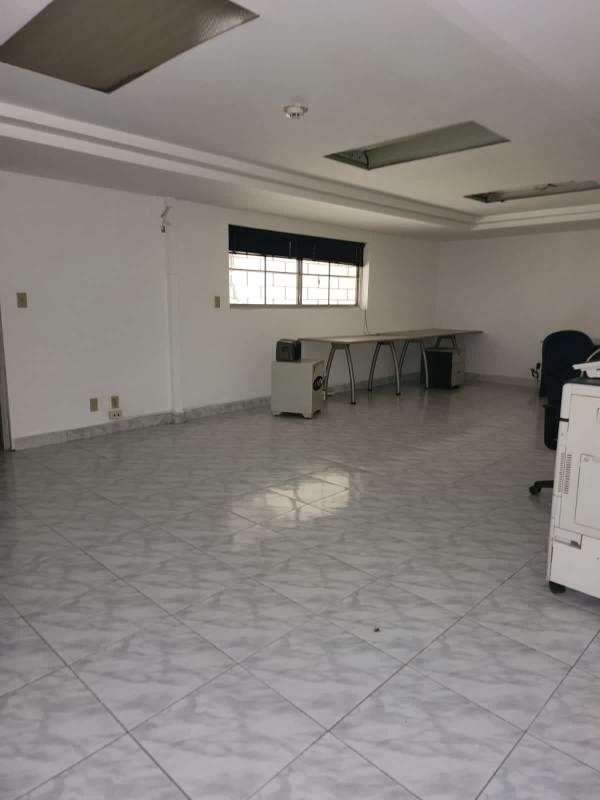 Large empty commercial office space with tiled floor, desk, and ceiling lights in Urbanización La Boca Panama