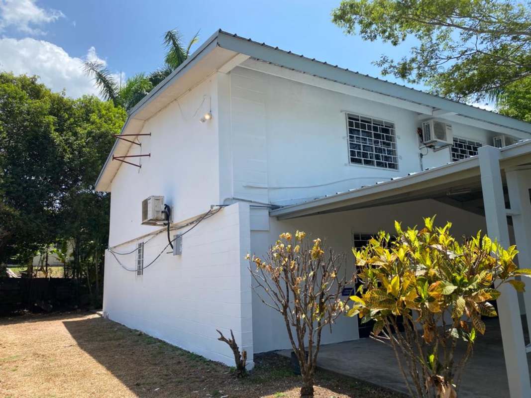Rear two-story office building view with carport garden and AC units Urbanización La Boca Panama