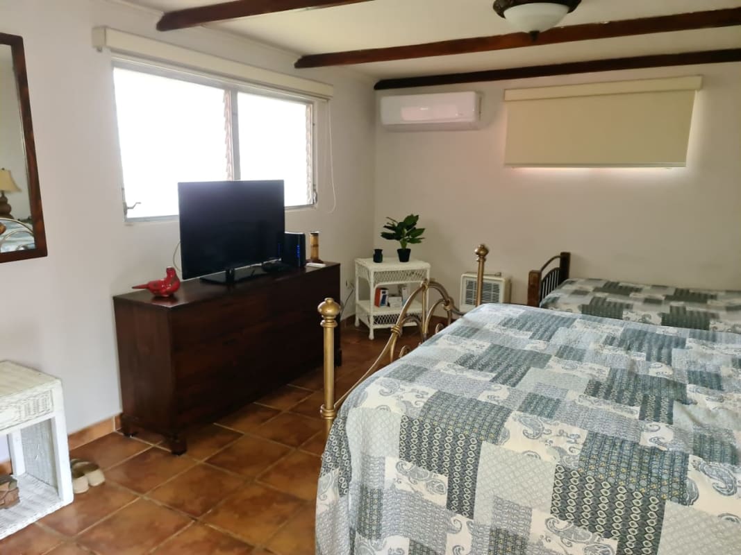 Spacious master bedroom with lounge, large windows wicker furniture countryside estate Coclé Panama