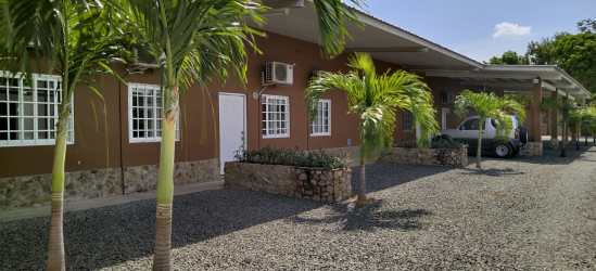 Single-story building with parking and palm trees at Rincon del Paraiso Rio Hato