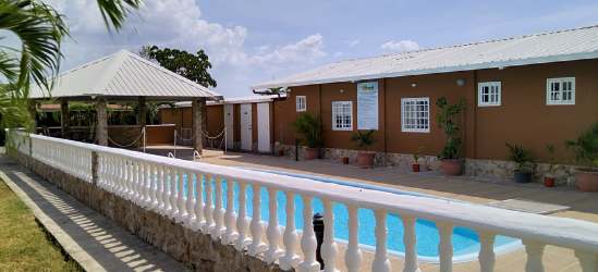 Outdoor pool with fence, gazebo, and deck at Rincon del Paraiso in Rio Hato Panama