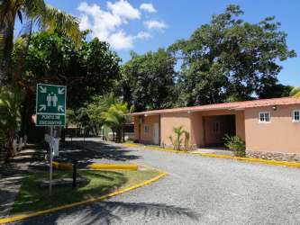 Single story pinkish-brown apartment building with red tile roof in Río Hato Panama