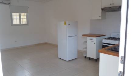 Bright kitchen with window, white cabinetry, and appliances in Río Hato rental apartment