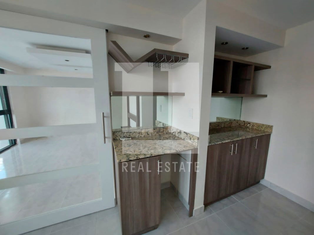 Spacious kitchen with granite countertops, wood cabinets and appliances at PH Brisas de Marbella Panama City