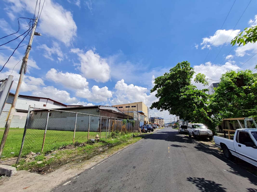 Vacant lot fenced next to mixed industrial residential buildings Rio Abajo