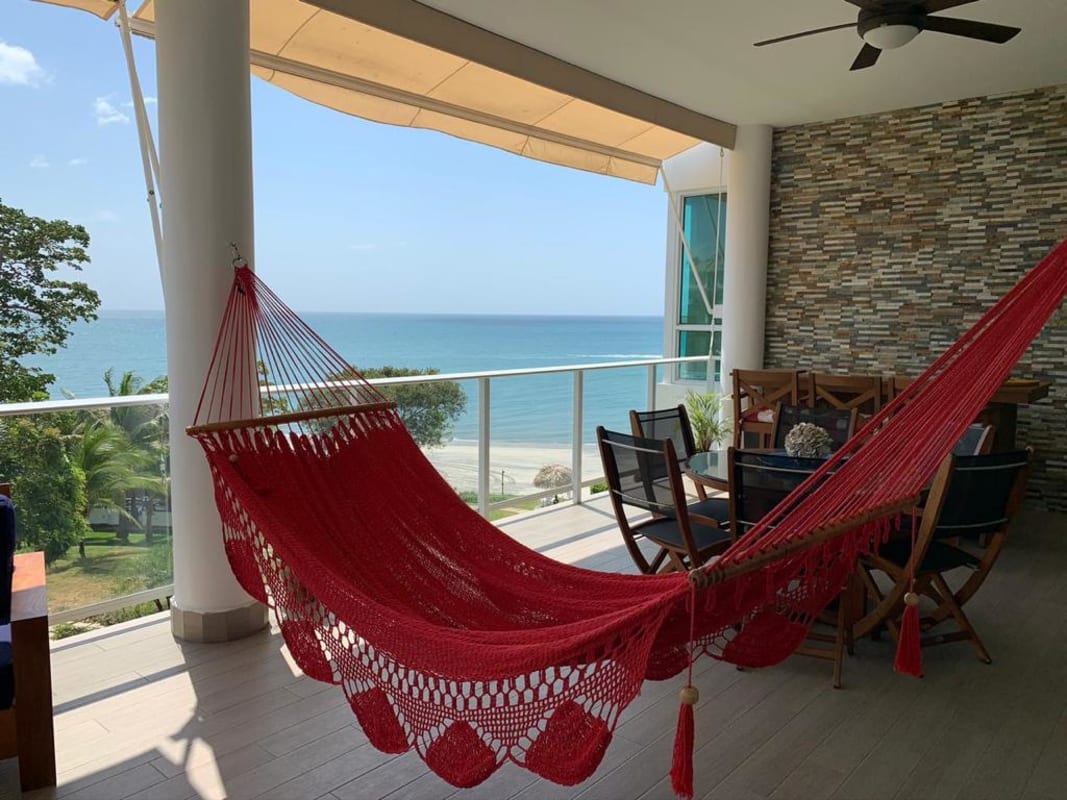 Oceanfront covered balcony with hammock, dining seating, panoramic Pacific view in Bijao Beach Condo Panama
