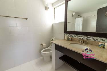 Bright bathroom with granite vanity, large mirror, shower in luxury beach golf home Panama