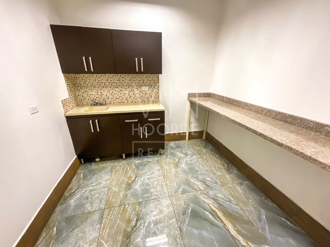 Compact kitchenette with mosaic backsplash, granite top, dark cabinets in Torre Arifa Panama