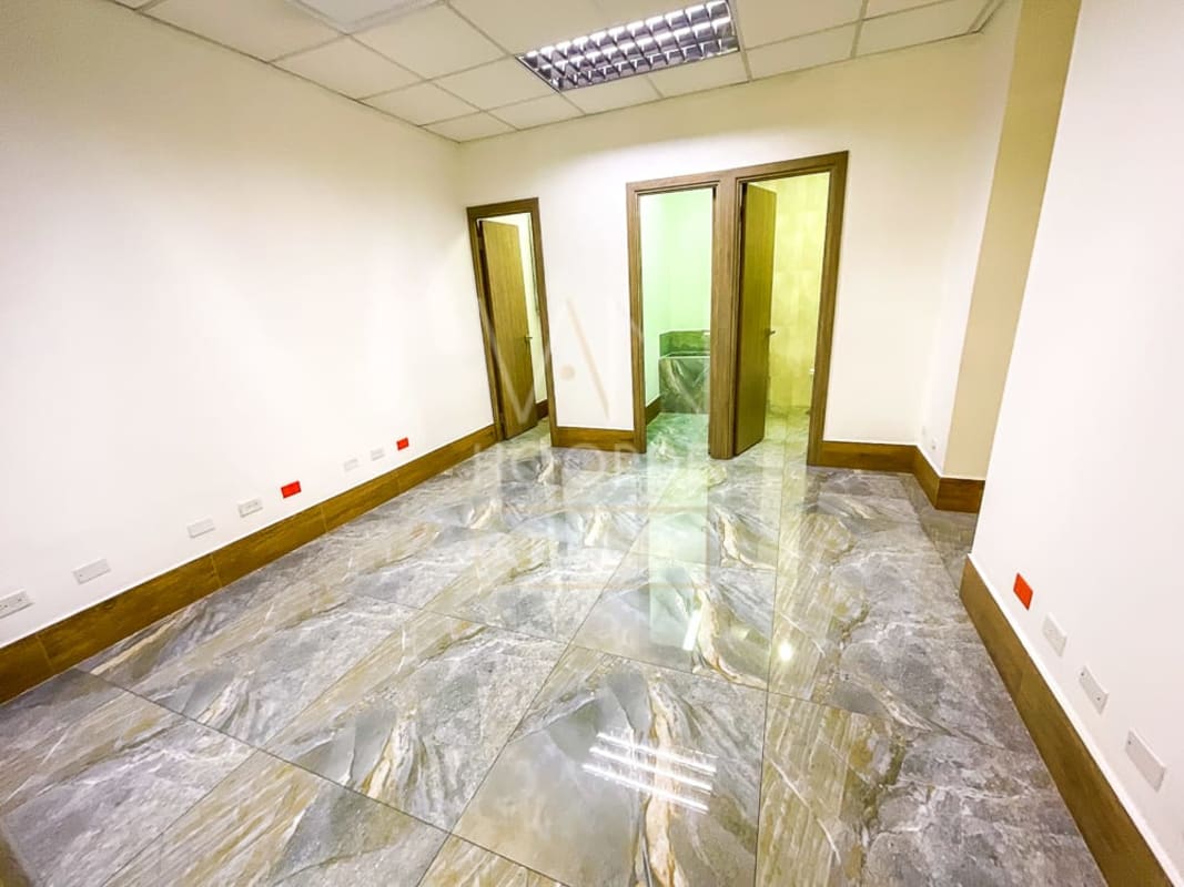 Spacious empty office with marble look tile floors and fluorescent lighting in Torre Arifa Panama