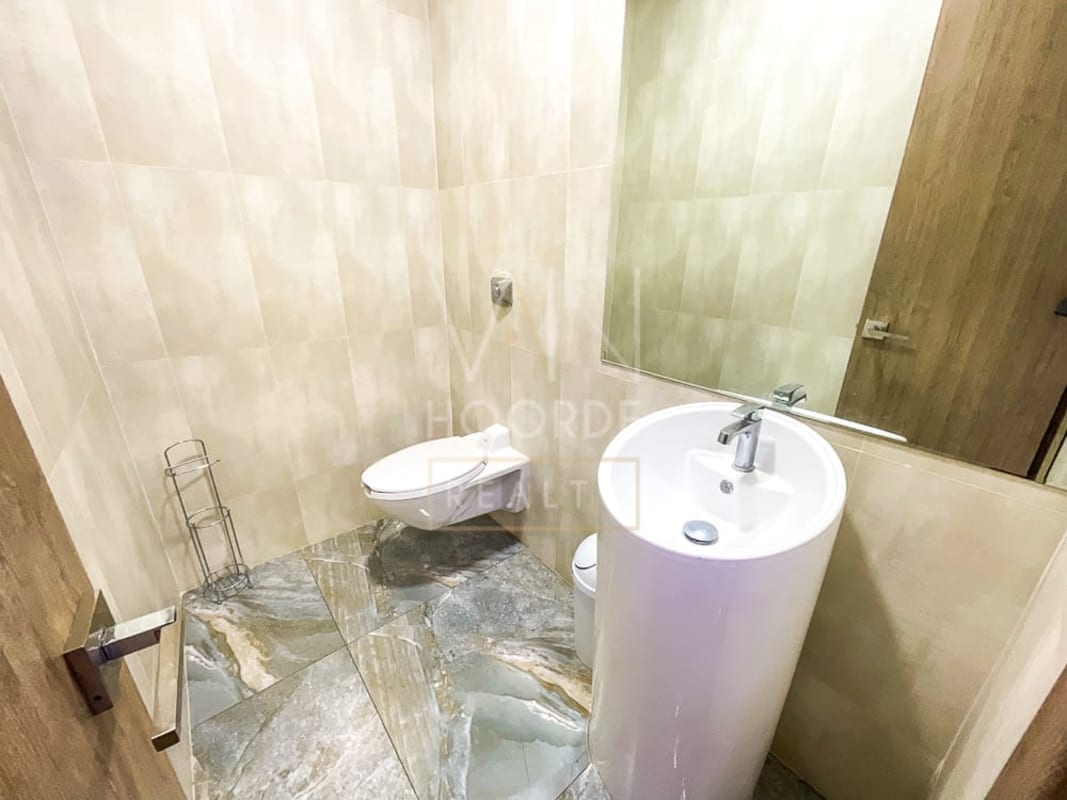 Modern wall-mounted toilet and pedestal sink with large mirror in Torre Arifa Panama