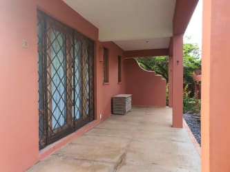 Spacious covered patio with terracotta colors, large glass doors and garden views at beachfront Ocean Loft house Pedasi Panama