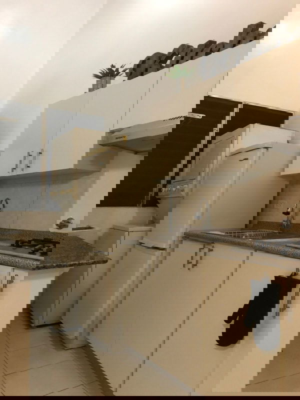 Compact kitchen granite countertops white cabinets gas stove and laundry PH Llano Bonito Panama City