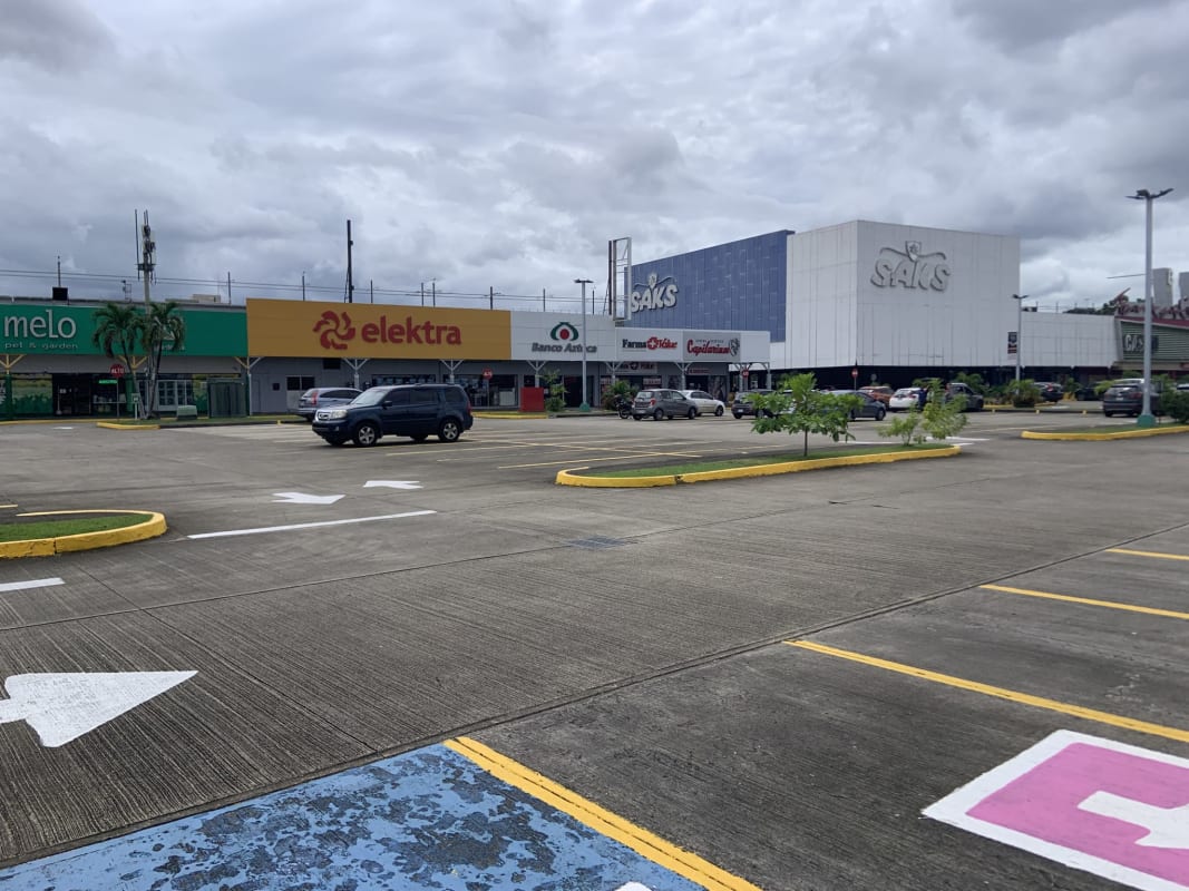 Wide shopping plaza with storefronts, ample parking and signage Centro Comercial Los Pueblos Panama