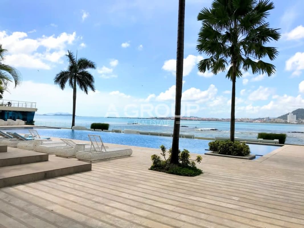 Luxurious infinity pool with sun loungers waterfront views at The Point Tower Panama