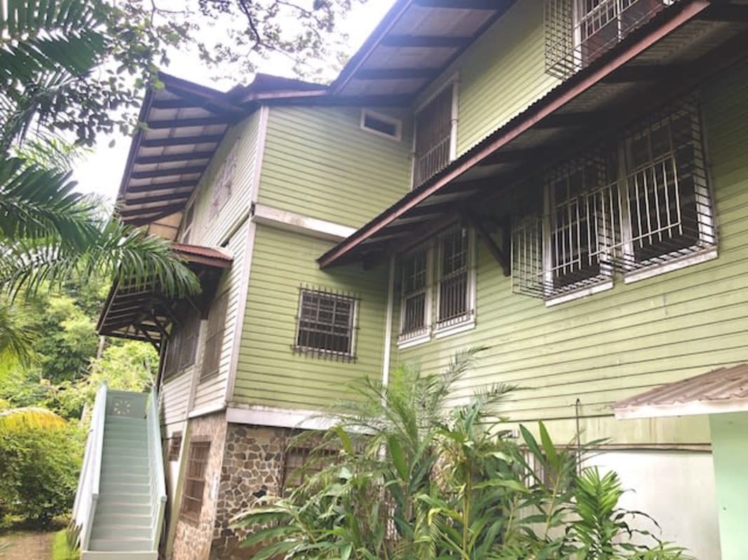 Rustic tropical house facade stone base wooden siding Herrick Heights Panama