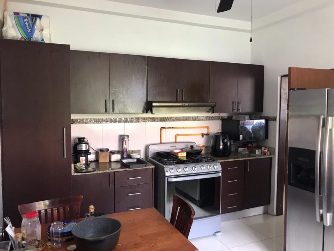 Patio with bar counter, wicker furniture overlooking lush backyard and pool at El Doral Betania