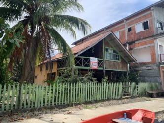 Rustic wooden Caribbean house with balcony and green fence Isla Grande beachfront