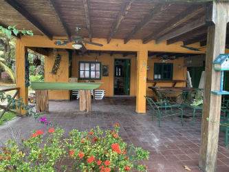 Covered patio with rustic ceiling, terracotta tiles and garden view Isla Grande Panama