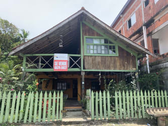 Rustic wooden Caribbean home with balcony and green garden fence Isla Grande Panama