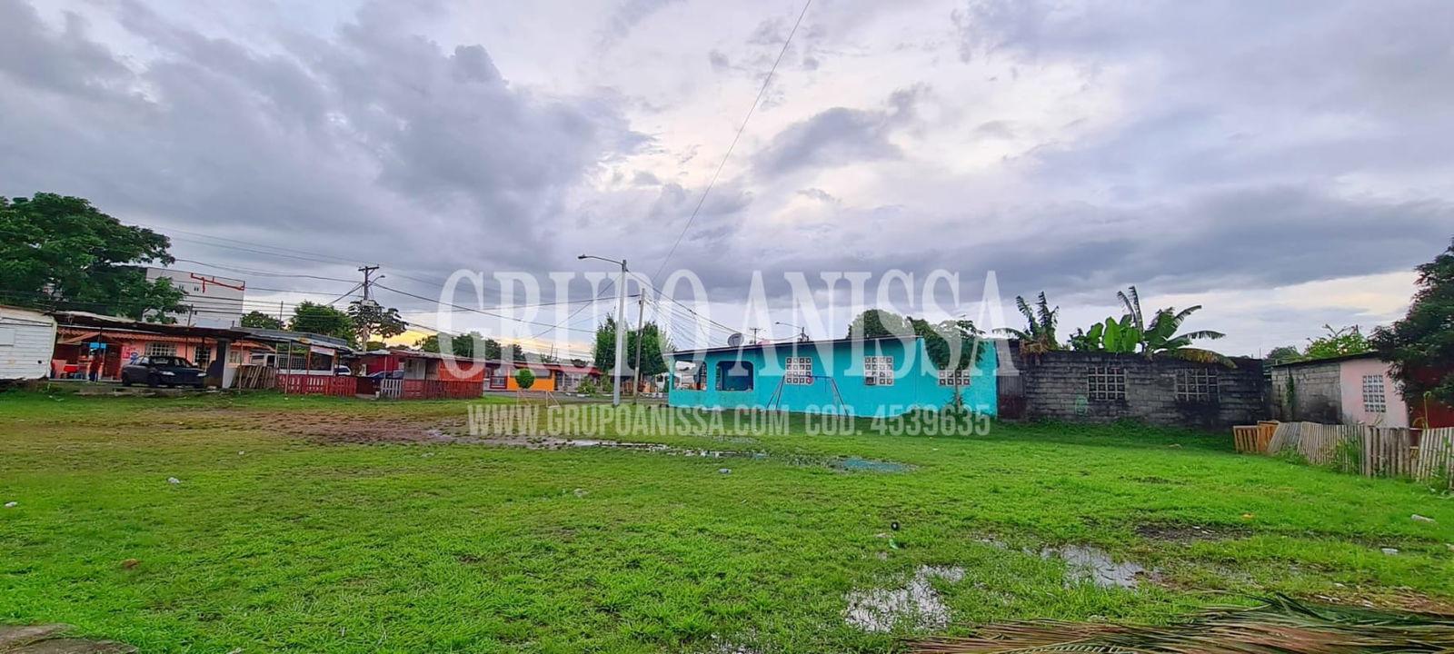 Residential urban lot with green grass, houses around, electricity access in Juan Díaz Panama