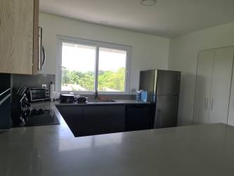 Open plan living room kitchen with bar stools Punta Chame beach condo Panama for sale