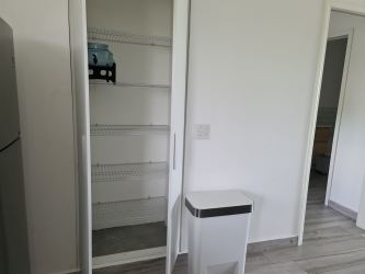 Modern kitchen pantry white cabinets and stainless fridge in Punta Chame beach condo Panama