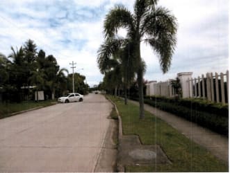 Tree-lined paved road and sidewalk at edge of Antón Coclé land for sale near Bijao resort