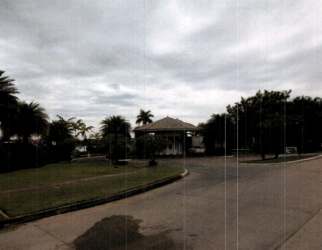 Entrance with guard booth and palm trees near vacant development land in Coclé Panama nearby Ibiza Village