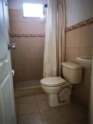 Bathroom with shower, toilet and tiled walls in Panama house for sale
