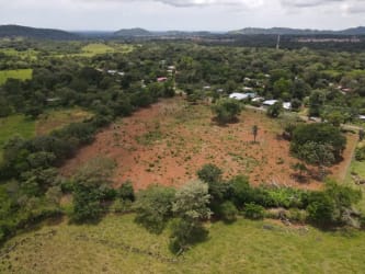 Vacant land parcel with sparse vegetation and main road access, countryside Dolega Panama