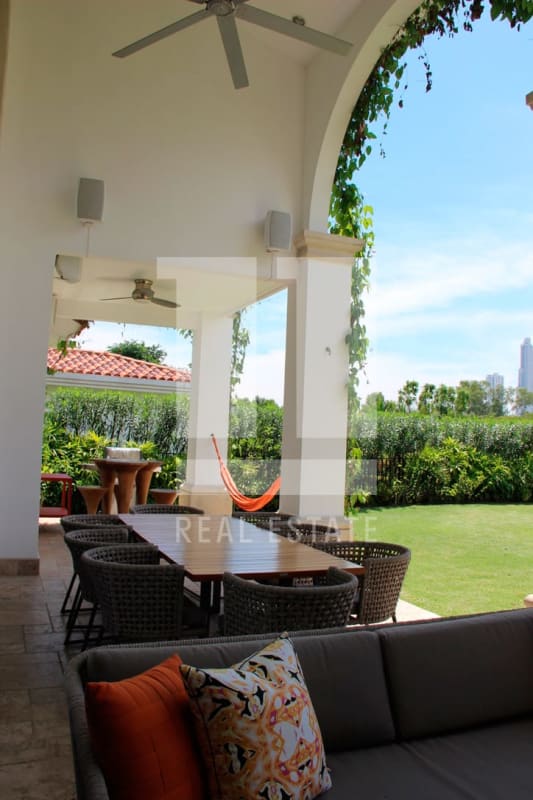 Covered terrace with dining, lounge, hammock overlooking garden golf community Santa Maria Panama