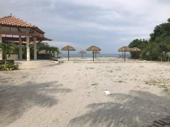 Sandy beachfront area with palapa umbrellas and gazebo at PH Coral Fontanella San Carlos Panama