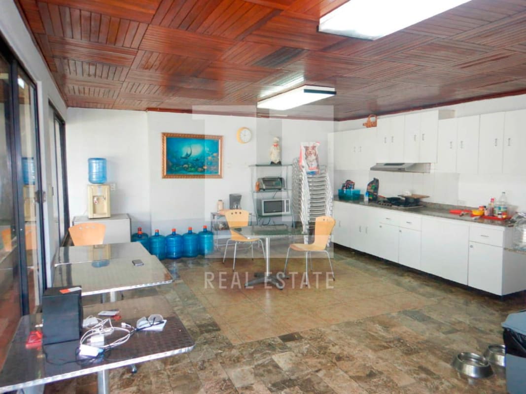 White utility shed with metal roof for storage in garden of Coco del Mar commercial property