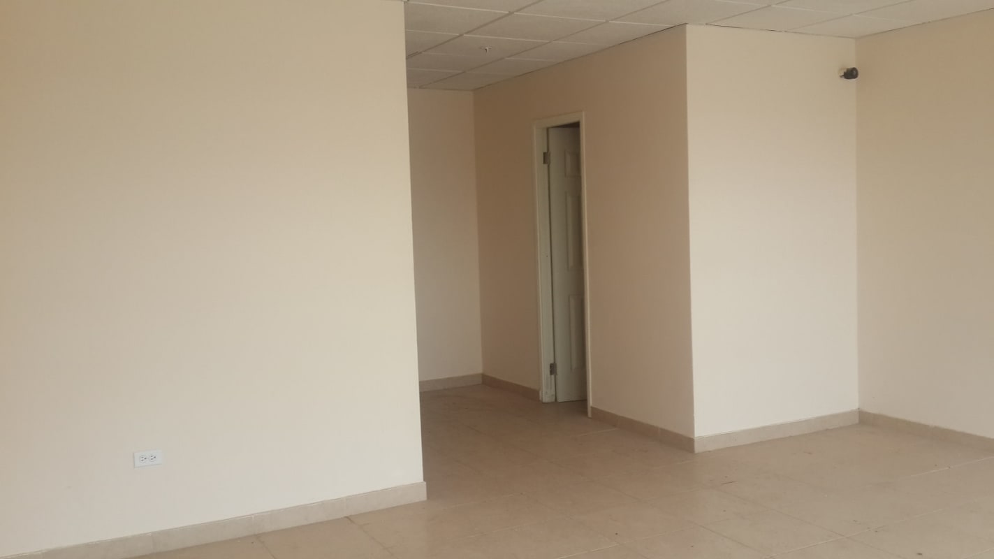 Empty room inside commercial warehouse with tiled floors and drop ceiling, suitable for office or storage Panama