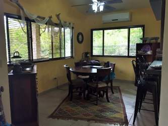 Cozy living room with windows overlooking greenery in Siena sector villa Altos del María Panama