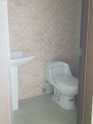 Simple bathroom with beige tiles pedestal sink in Lighthouse Tower Playa Blanca Panama